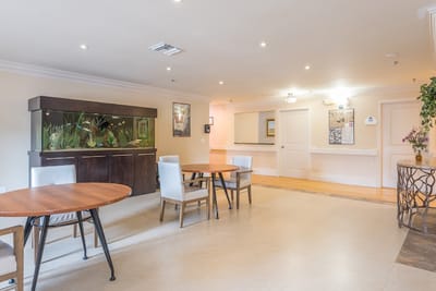 Bright common area with seating and an aquarium