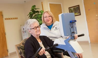 Staff helping a resident with therapy equipment