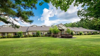 Exterior view of Dudneywood Assisted Living building surrounded by grass