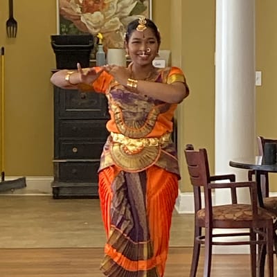 A performer in traditional attire dancing in a communal space