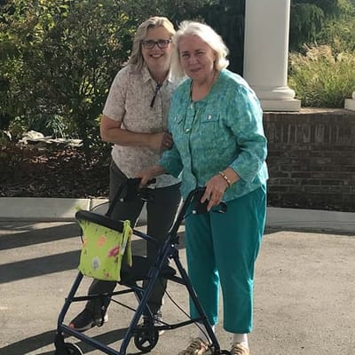 A caregiver assisting a resident outdoors