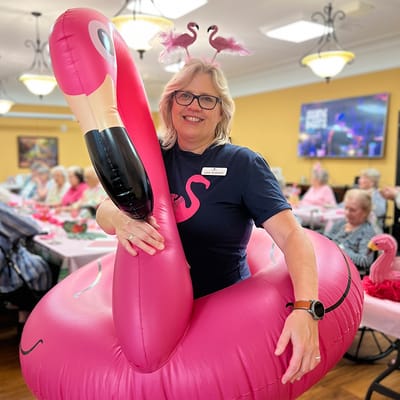 Staff member in a flamingo inflatable at a celebration