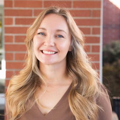 Smiling staff member in front of a brick wall