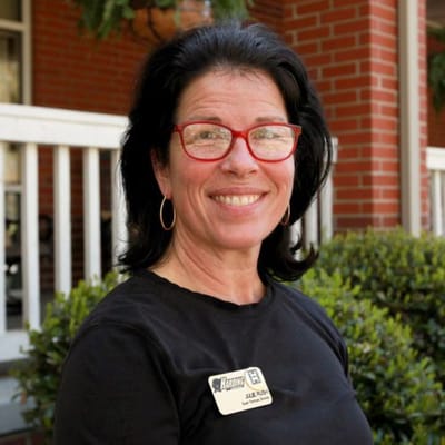Staff member smiling in front of the facility