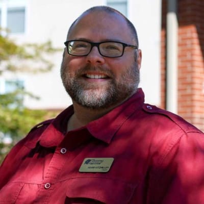 Staff member smiling outdoors at the facility
