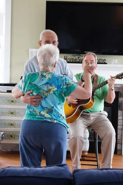 Residents dancing with live music in a bright common area