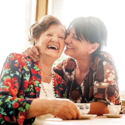 Two women laughing together at a table