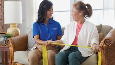 Staff assisting a resident with exercise in a cozy living space