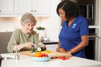 A caregiver assisting a senior resident in the kitchen
