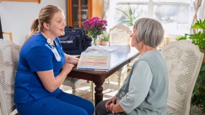 Caregiver discussing with a senior at a dining table