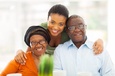 A caregiver with two elderly residents smiling together