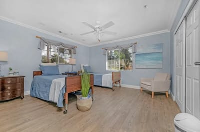 A shared resident room with two beds and light decor