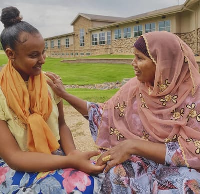 Two women enjoying time outdoors, smiling at each other