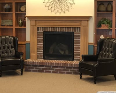 Cozy seating area with a fireplace and bookshelves