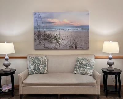 A cozy sitting area with beach-themed wall art and lamps