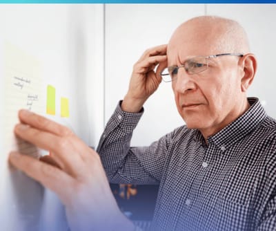 Elderly man looking at notes on the wall