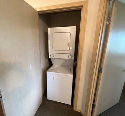 A stacked washer and dryer in a small closet