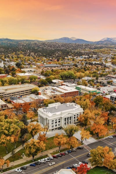 Aerial view of a large building surrounded by fall foliage