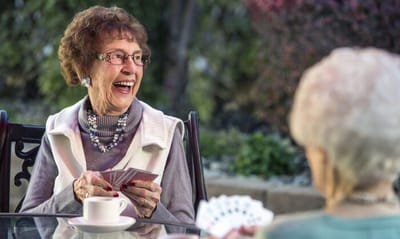 Seniors playing cards and enjoying conversation outdoors