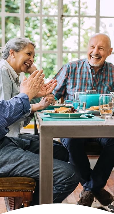 Residents enjoying a meal and conversation in a common area