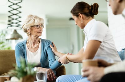A caregiver engaging with a senior resident in a living space