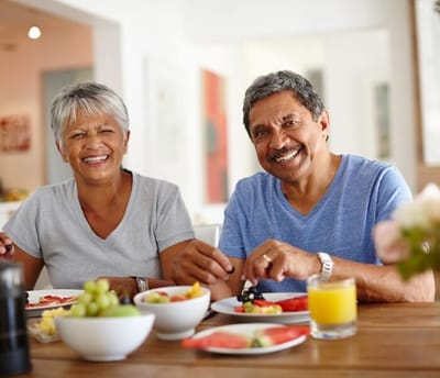 Two seniors enjoying a meal together in a dining area
