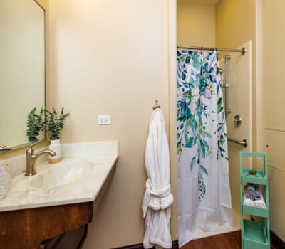 Bright bathroom with floral shower curtain and towels