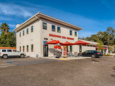 Exterior view of a market building with outdoor seating