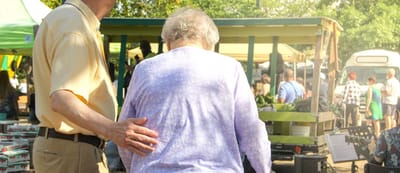 A resident with staff assistance at an outdoor market