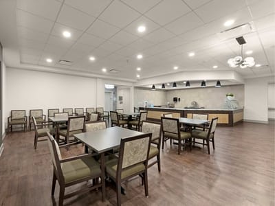 Bright dining room with tables and chairs set up