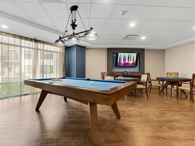 Bright game room with a pool table and seating area