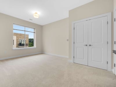 A vacant resident room with beige walls and carpet