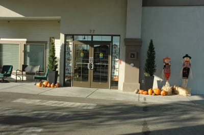 Exterior entrance decorated with fall pumpkins and scarecrows