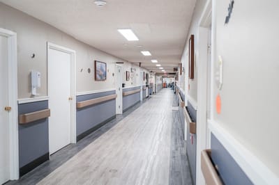A well-lit corridor in the nursing home facility