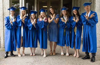 Graduates posing in blue gowns outdoors