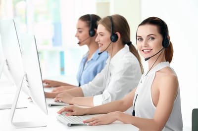 Three women in headsets working at computer stations