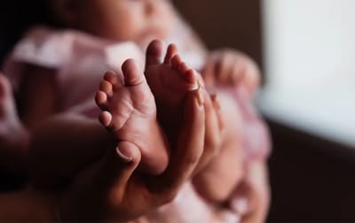Close-up of a caregiver holding a baby's feet