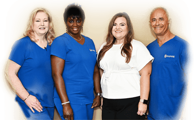 Group of staff members posing in blue scrubs