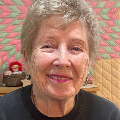 A smiling resident in an interior setting