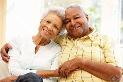 Smiling elderly couple sitting together indoors