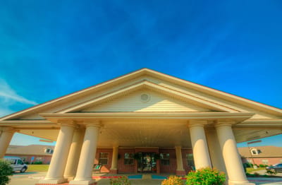 Timberlane Health & Rehab, assisted living in El Dorado, AR — Senior living facility entrance with columns and blue sky