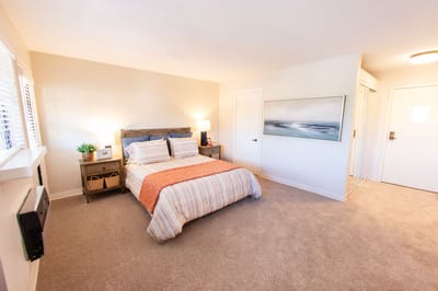 Well-decorated private resident room with bedding and artwork