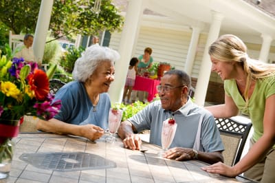 Two seniors enjoying ice cream on a patio