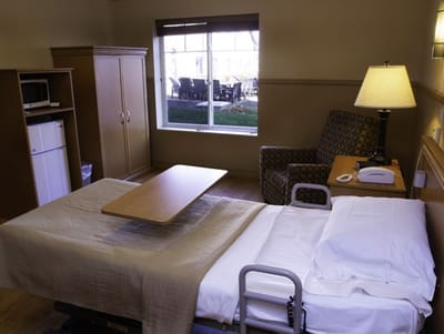 Interior view of a resident room with a bed and seating area