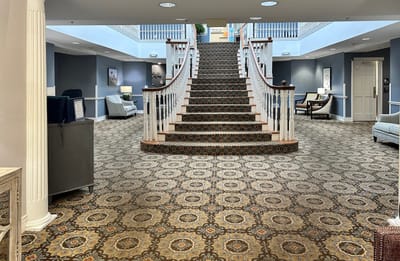 A spacious lobby with a grand staircase and seating areas
