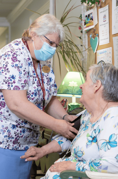 The Inn at Fairview, nursing home in Hudson, NH — Caregiver assisting a resident in a cozy setting