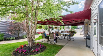 The Inn at Fairview, nursing home in Hudson, NH — Patio area with seating under a red awning
