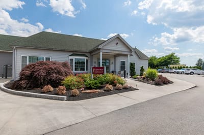 The Inn at Fairview, nursing home in Hudson, NH — Entrance of a senior living facility with landscaped gardens