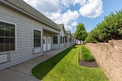 The Inn at Fairview, nursing home in Hudson, NH — Pathway lined with greenery and residential buildings