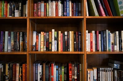 The Inn at Fairview, nursing home in Hudson, NH — Books arranged on wooden shelves in a library setting